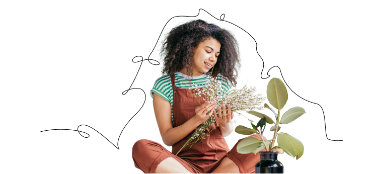 Woman sitting down and tending to houseplants